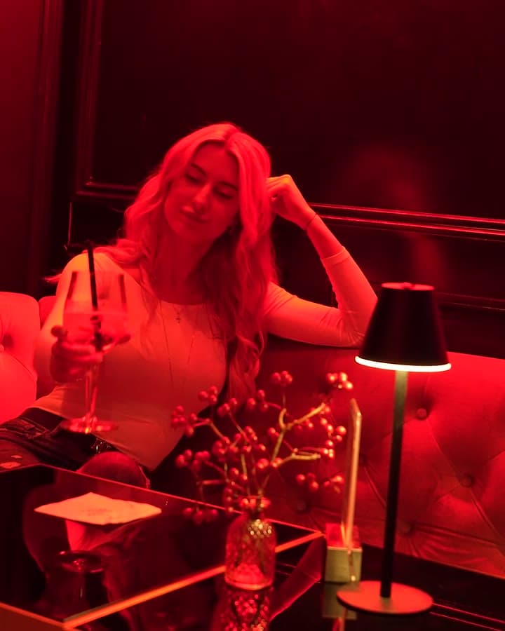 Monchis: rot beleuchtete Lounge, Gast mit Drink an der Samtbank
